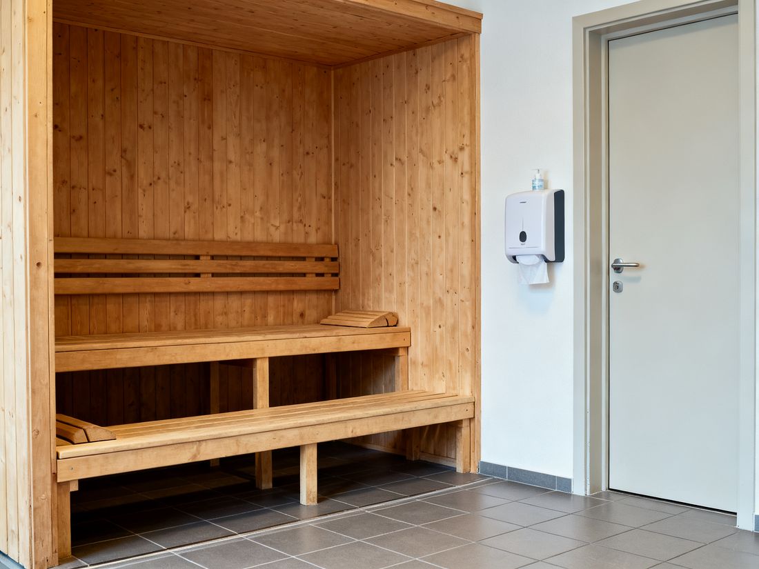 Leere öffentliche Sauna mit Hygienespender neben der Tür